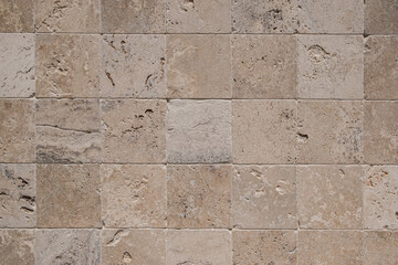 Wall with limestone tiles closeup as stone background