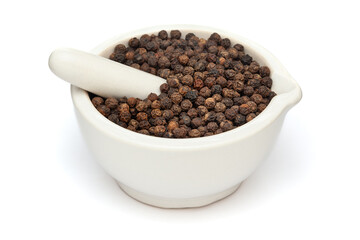 Close-up of Dry Organic Black Pepper (Piper nigrum), in white ceramic mortar and pestle, isolated on a white background.