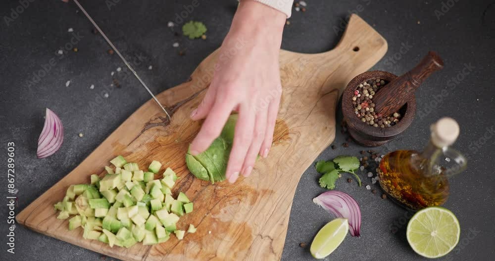 Canvas Prints Woman Cutting slicing fresh green avocado fruit with knife on a wooden board at domestic kitchen