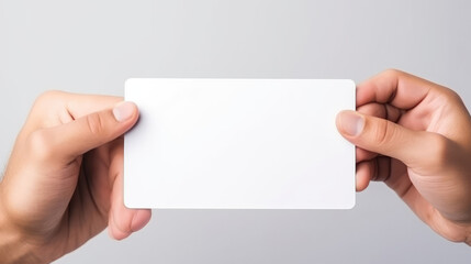 Fototapeta premium Close up of man hand holding blank advertising card on white, mock up, generative ai