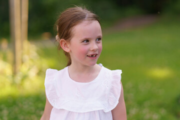 Sweet little girl, one tooth short, having a blast in the sun on a hot day.