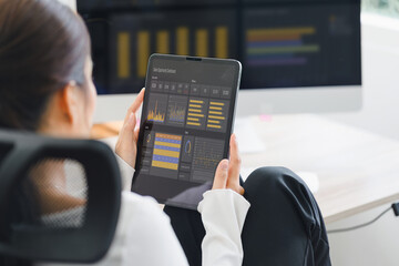 Businesswoman interacts with a digital sales dashboard displaying various performance metrics and analytics.