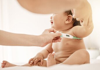 Baby, care and parent in home with thermometer, fever testing and child with temperature monitor in house. Health, pediatric wellness and check for illness, axillary method and people in nursery