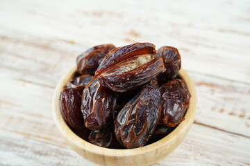 Sweet dates fruit heap in the bowl. Dried date palm fruits or kurma, ramadan food