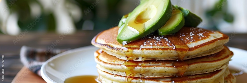 Poster a stack of fluffy pancakes topped with sliced avocado and agave syrup instead of butter and syrup.