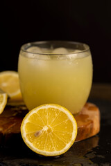 a close-up of lemons and a glass of lemon natural juice