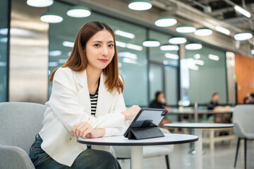 Young asian businesswoman with tablet working in the office. Start up freelancer people posing while using digital tablet working in the modern office. Lifestyle business female.