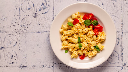 Sacсhettini pasta in a plate with tomato sauce.