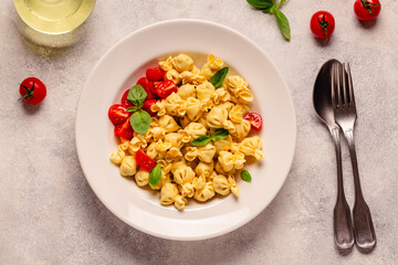 Sacсhettini pasta in a plate with tomato sauce.