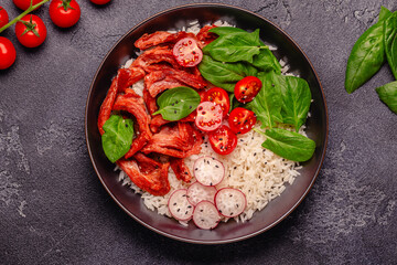 Bowl with vegan fried soy meat and vegetables served with boiled rice.