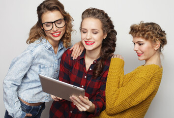 Three hipster female friends use digital tablet