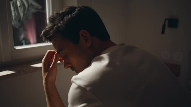 Man pondering problems bedroom by window moonlight closeup. Sleepless guy on bed