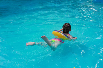 little girl with inflatable in swimming pool