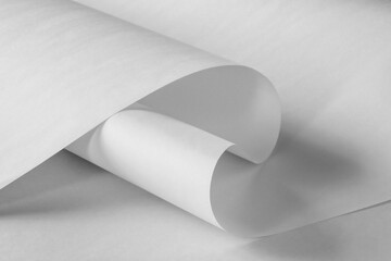 A curved sheet of white paper in black and white.