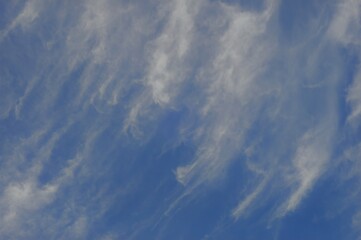 Soft streaks of white clouds against a bright blue sky, creating a calm and peaceful atmosphere.