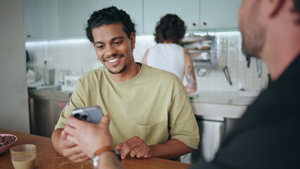 Cheerful friends resting restaurant exchange phone numbers closeup. Guys meeting