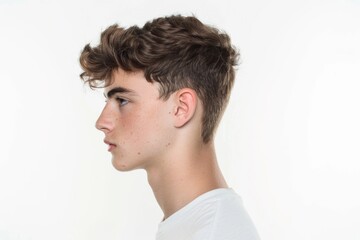 Fototapeta premium A young man holds a cell phone to his ear, possibly having a conversation