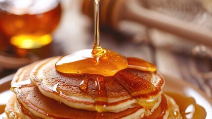Fototapeta premium There is a stack of pancakes on the table, drizzled with sweet honey. A traditional feast for the holiday. Homemade sweets.