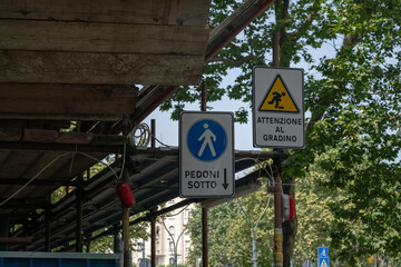 Fototapeta premium construction site building, pedestrian crossing under scaffolding on a construction site, signs indicate the direction and be careful not to trip.