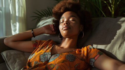 A woman is lying down on a comfortable-looking couch, her eyes are closed