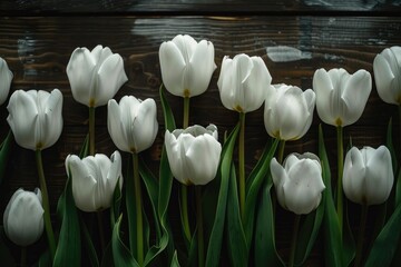 Obraz premium A bouquet of white tulips resting on a wooden surface, great for floral arrangements or still life photography