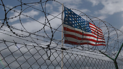 USA waving flag with barbed wire fence