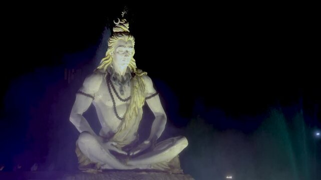 idol of hindu holy god lord shiva sitting in mediation at outdoor at night