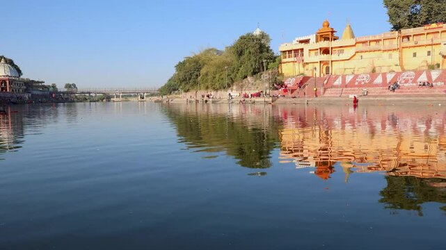 pristine holy Shipra river shore with ancient temple and bright blue sky at morning