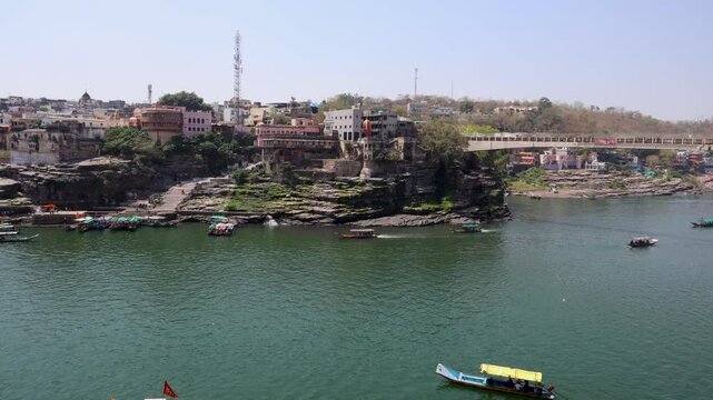 city situated at holy river bank with tourist ferry boats at morning