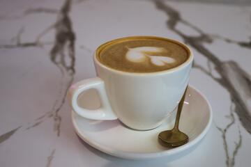 Coffee in a white cup on a marble table