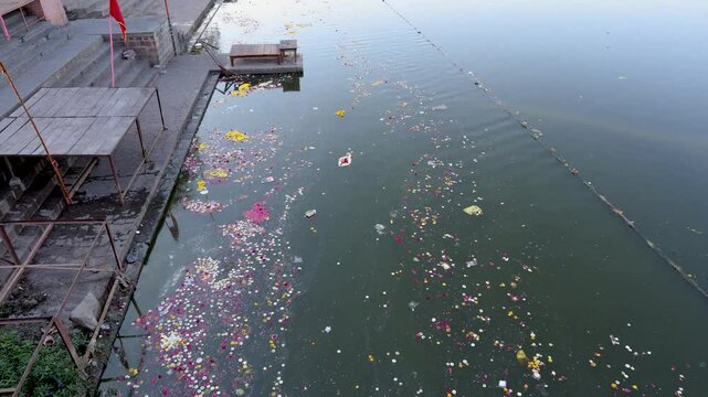 religious holy riverbank with flowers and religious waste at morning