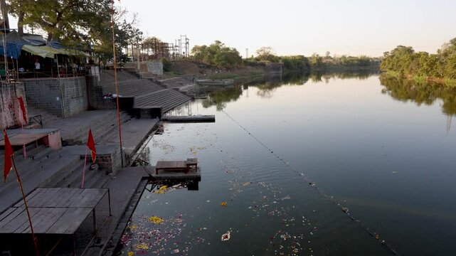 religious holy riverbank with flowers and religious waste at morning