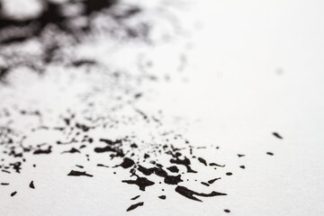 Extreme close up of black acrylic paint texture on paper. Selective focus.