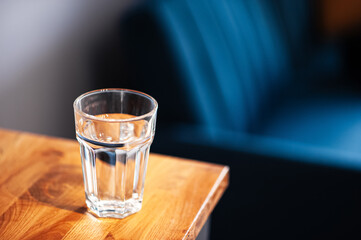 In a kitchen setting, a glass of water rests on the table, surrounded by dark blue hues that create a soothing atmosphere