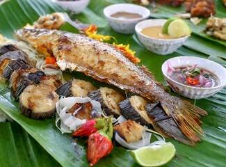 A sumptuous Polynesian feast featuring grilled fish, taro leaves, and other traditional food