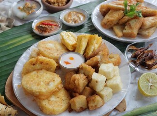 Various fried foods served on plates that are famous in Indonesia, such as corn bakwan