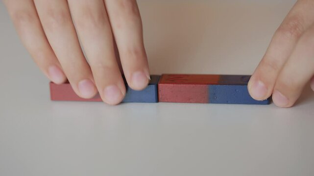 School Science Educational Experiment With Magnets. Child Hands Moves Two Magnets Around So That They Attract And Repel Each Other. Magnetic Force Demonstration Showing Attraction And Repulsion.