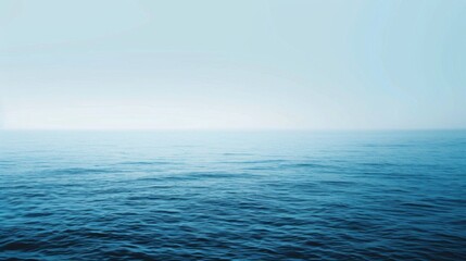 The image features a tranquil ocean with gentle waves under a serene blue sky, offering a peaceful view of the distant horizon with a sense of infinite calmness.
