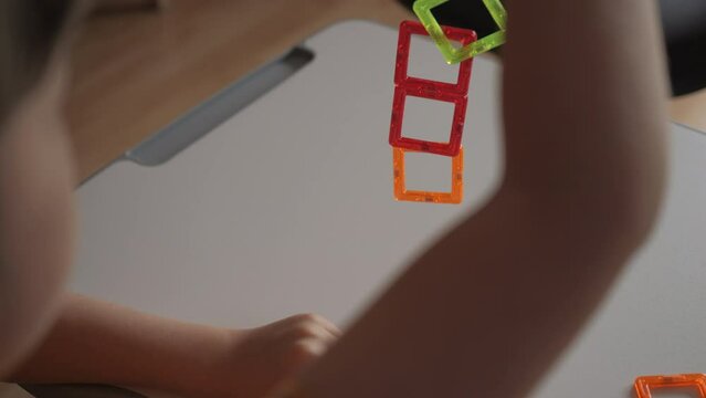 Child Creates Figures With Magnetic Construction Set. Boy Playing With Magnetic Tiles Stacking Blocks Game Set Toy. Development of Attention and Imagination. Creativity and Learning in Childhood.