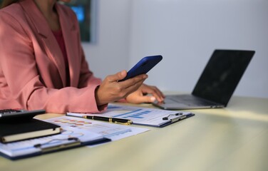 Image of a young Asian female company employee smiling and holding a digital tablet standing on a white background.