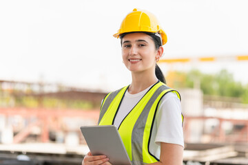 Cheerful female engineer with a digital tablet at the factory warehouse, Young beautiful woman foreman worker in the construction site