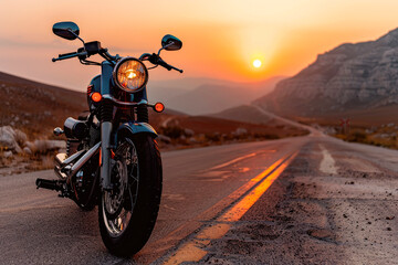 Naklejka premium A retro motorcycle on the road with mountains and a sunset in the background.