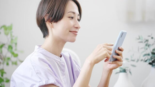 スマートフォンを操作する若い女性　ライフスタイルイメージ	
