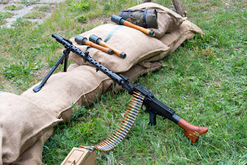 WWII German MG 34 machine gun and hand grenades next to sandbags