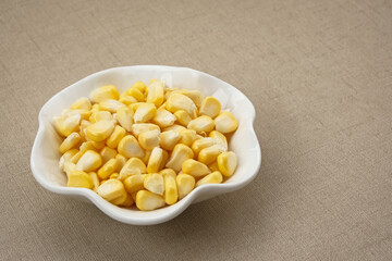 Raw fresh corn seeds on white bowl
