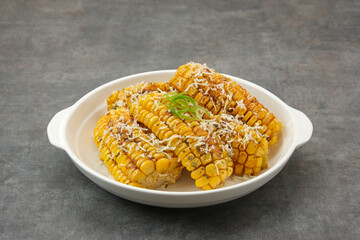 Homemade spicy corn ribs with barbecue sauce and grated cheese
