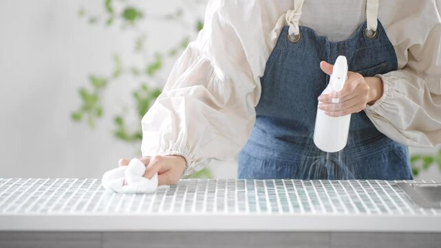キッチンを掃除するエプロン姿の女性　ライフスタイルイメージ