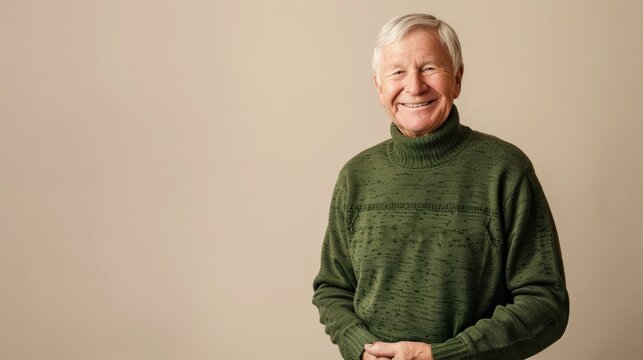scandinavian caucasian smiling old man is 65 years old with blond hair dressed in green sweater on beige background