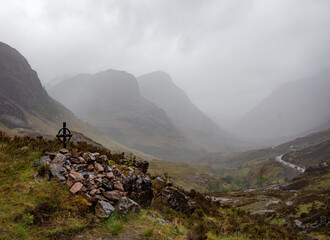 Ralston memorial viewpoint, valley of Glencoe, Scotland, with road and foggy mountains in background