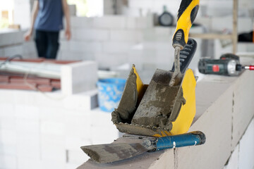 Construction Site with Worker in Background Building Interior Walls from Aerated Concrete, Tools...